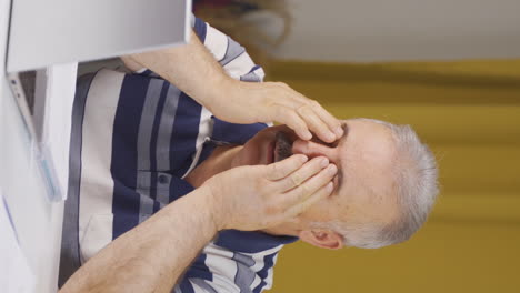 Vertical-video-of-Home-office-worker-old-man-has-eye-pain.